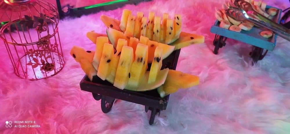 Carved yellow watermelon arranged on a lit display cart