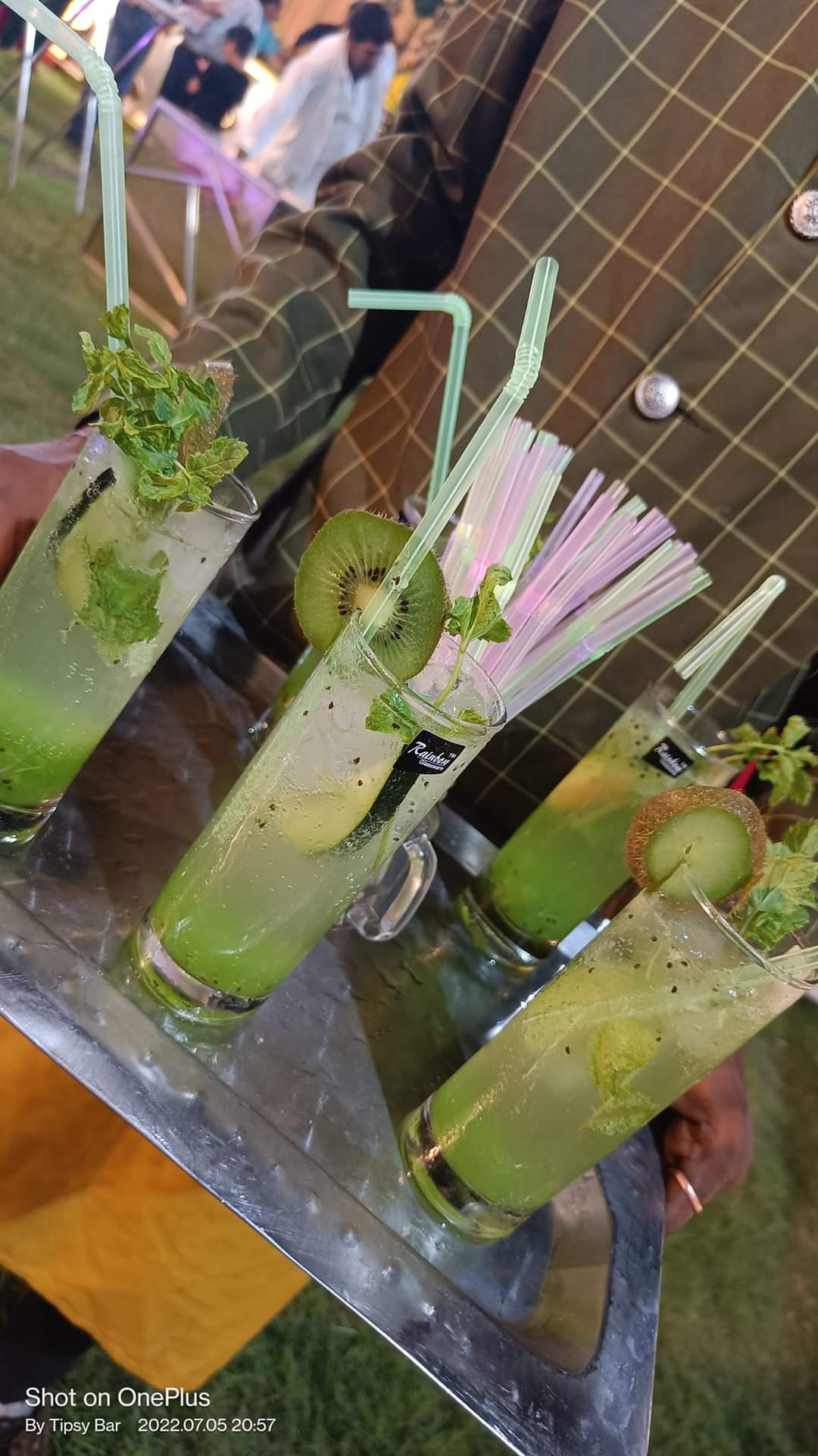 A tray of kiwi mojitos being carried out to guests