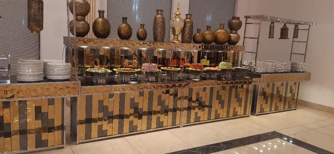 Glass and mirrored buffet counter laid with salad bowls and tall vases