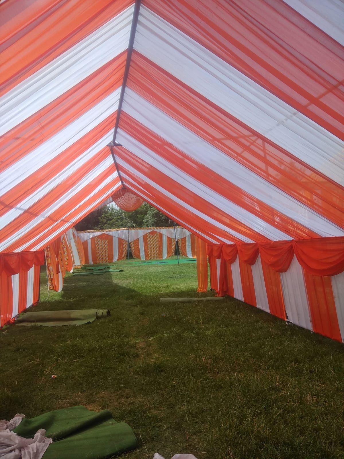 Red and white striped pitched tent erected on a lawn